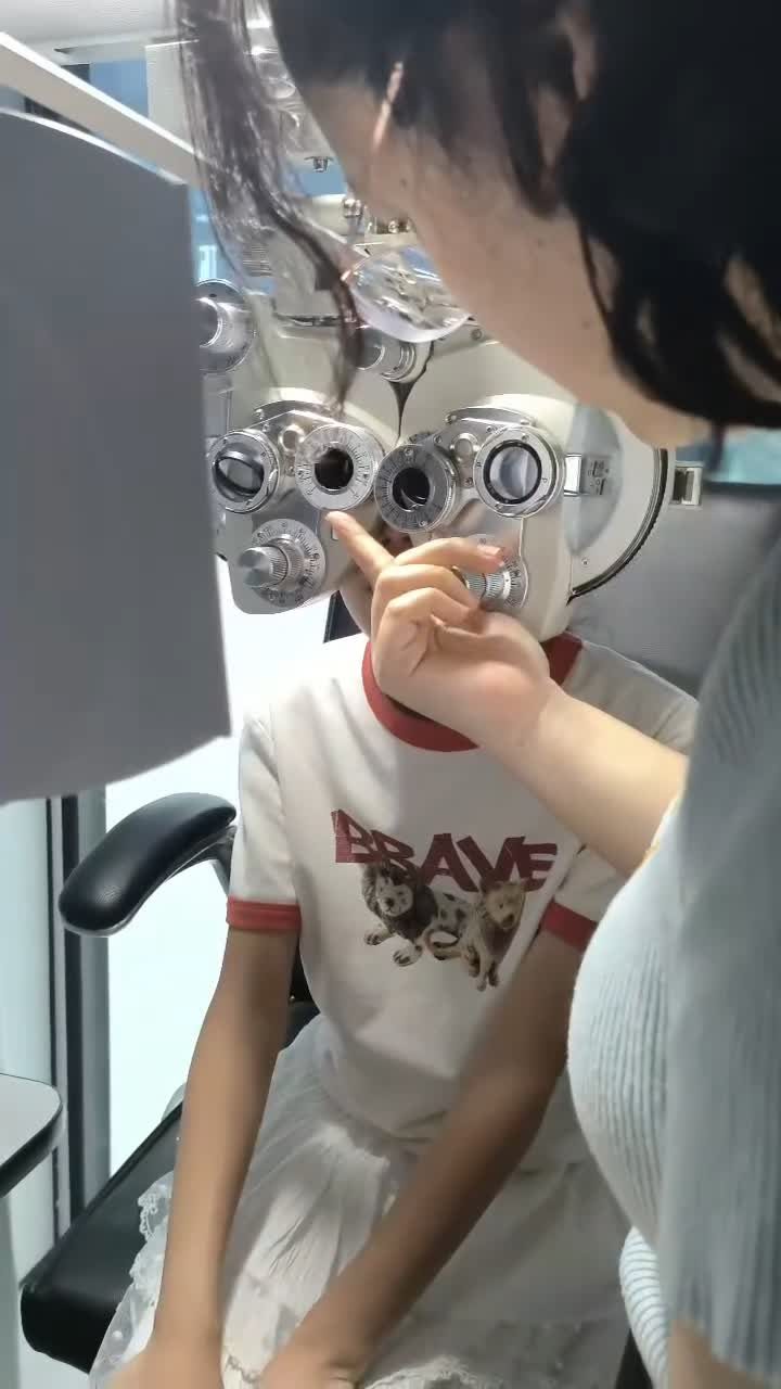 中康视光眼镜验光师为孩子做单眼视力与矫正视力检查